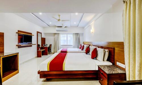 a hotel room with a bed and a television at Hotel U.T.Elegance in Bangalore