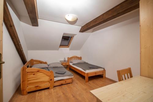 um quarto com duas camas e uma mesa em Szobi Malomkert Lovarda em Szob