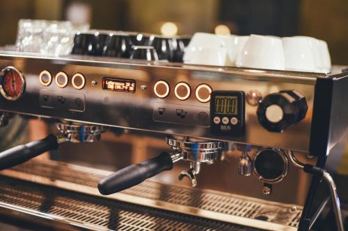 a coffee machine on a counter in a coffee shop at Hotel Mount View Comforts in Tirupati