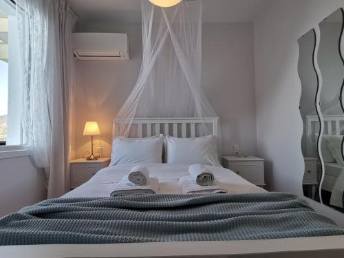Un dormitorio con una cama blanca con toallas. en Ithaca, en Perdika