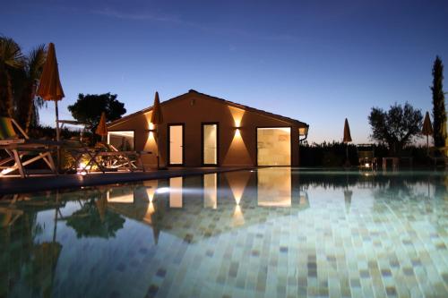 a swimming pool in front of a house at night at Agriturismo Verbena in Castiglione del Lago