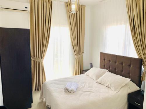 Karavas的住宿－Luxury Two-Bedroom Apartment in amazing place Lukomorye E5，一间卧室配有一张床,上面有两条毛巾