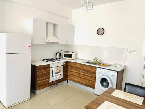 Karavas的住宿－Luxury Two-Bedroom Apartment in amazing place Lukomorye E5，厨房配有白色冰箱、洗衣机和烘干机