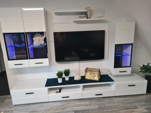a white entertainment center with a flat screen tv at Exklusive Ferienwohnung nahe der Nordsee in Wesselburen