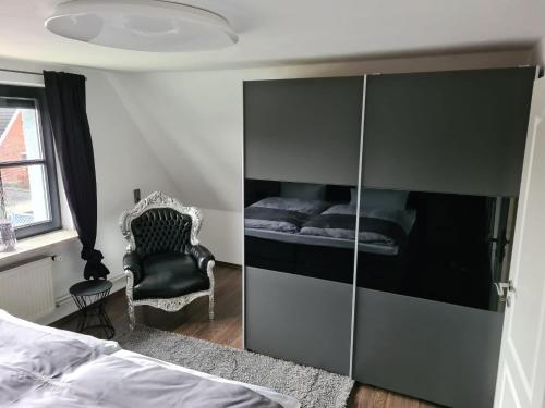 a bedroom with a large cabinet with a bed and a chair at Exklusive Ferienwohnung nahe der Nordsee in Wesselburen