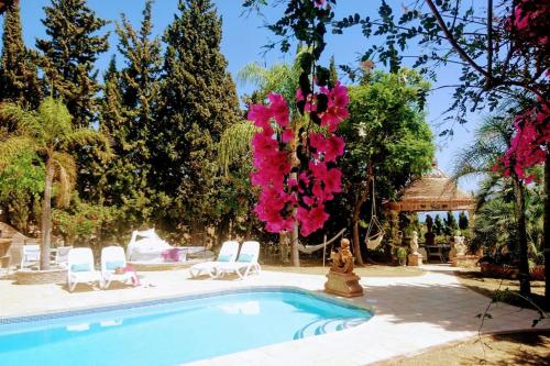 Villa con piscina y flores rosas en Casa Paraiso, en Benajarafe