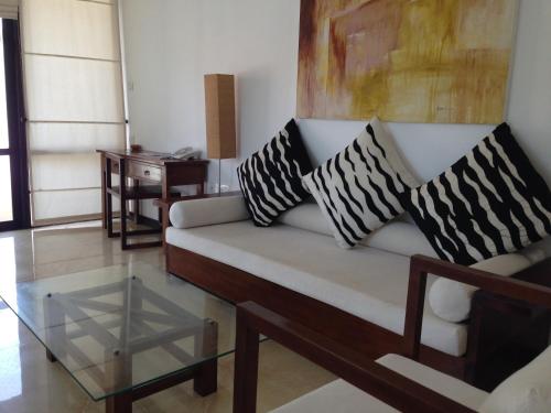 a living room with a couch and a glass table at Goldi Sands Hotel in Negombo