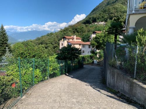 a street with a fence and houses on a hill at Apartment Casa Wiro in Magadino