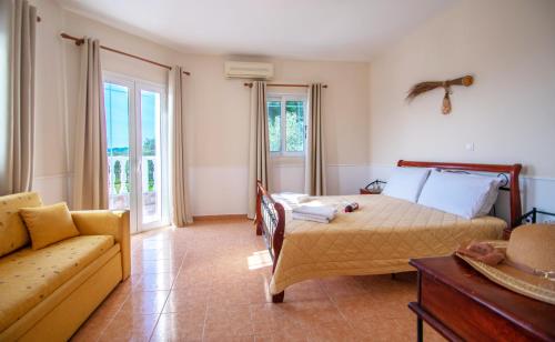 een slaapkamer met een bed en een bank bij Agios Sostis Village Apartments in Laganas