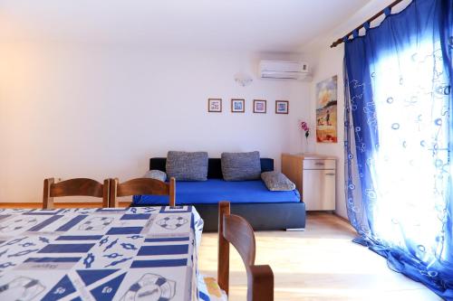salon z niebieską kanapą i stołem w obiekcie Apartments Melita w mieście Zadar