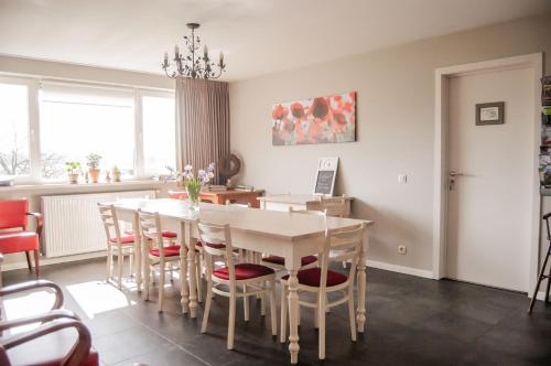 a dining room with a white table and chairs at LOGIES Tuin der Zinnen in Rijkevorsel