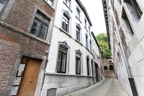 an alley with a brick building and a wooden door at GITADIN - Deluxe Suite Valens - Historical Center in Liège