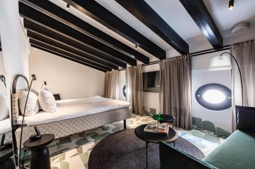 a hotel room with a bed and a couch at Concepcio by Nobis, Palma, a Member of Design Hotels in Palma de Mallorca