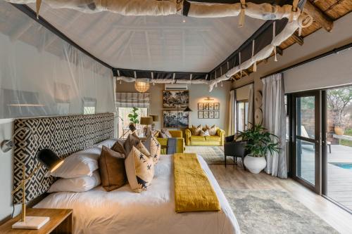 a bedroom with a large bed and a living room at Thornybush Simbambili Lodge in Sabi Sand Game Reserve
