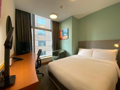 a hotel room with a bed and a desk with a television at Holiday Inn Express Hong Kong Causeway Bay by IHG in Hong Kong