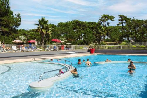 a group of people swimming in a swimming pool at Belambra Clubs Capbreton - Les Vignes in Capbreton