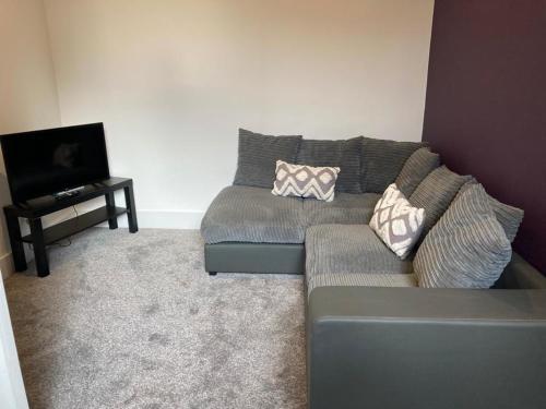 a living room with a couch and a tv at The Dockyard in Goole