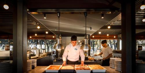 two men preparing food in a restaurant kitchen at Maistra Camping Amarin Glamping in Rovinj