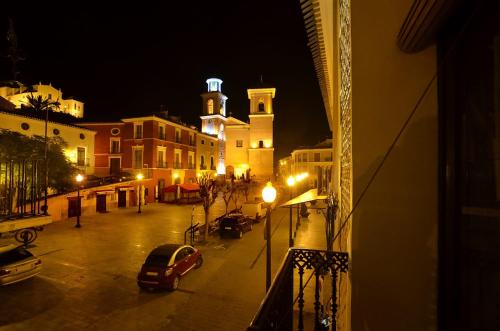 a city street at night with a clock tower at La Casa de los Coy in Mula