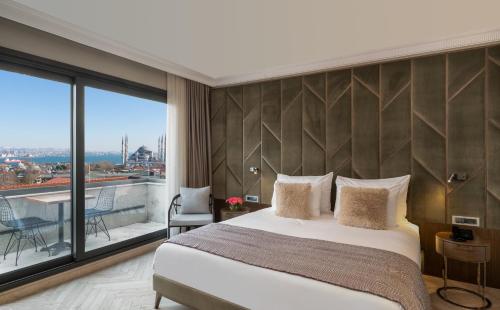 a bedroom with a large bed and a large window at Hotel Nena in Istanbul