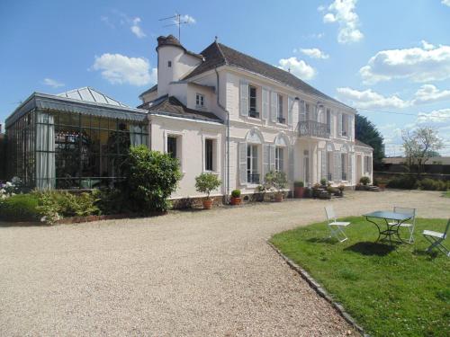 a large white building with a table in front of it at Clos Saint Nicolas in Neauphle-le-Château