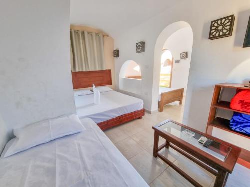 Habitación con 2 camas y mesa. en Coral Reefs Hotel Dahab en Dahab
