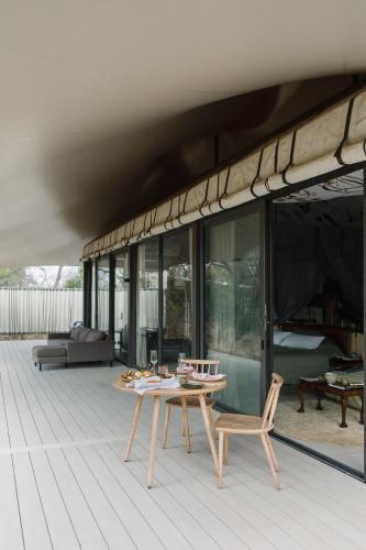 a patio with a table and chairs on a deck at Saseka Tented Camp in Hoedspruit