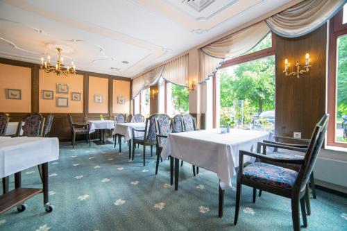 a dining room with tables and chairs and windows at Aspire Oldenburg, Trademark Collection by Wyndham in Oldenburg