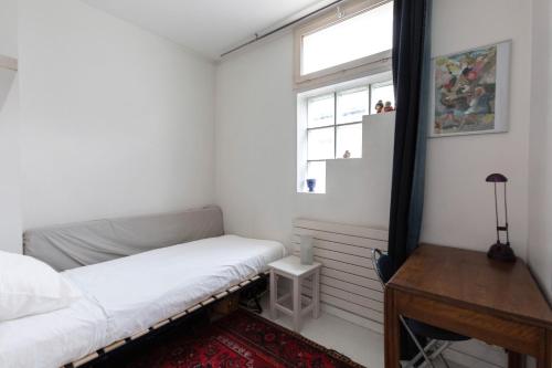 une petite chambre avec un lit et une fenêtre dans l'établissement Veeve - White House, à Paris