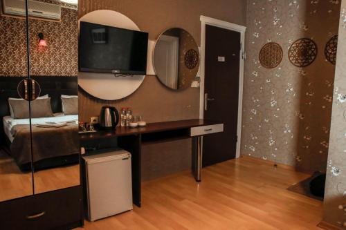 イスタンブールにあるレター ホテルのデスク、壁掛けテレビが備わる客室です。