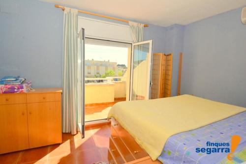 een slaapkamer met een bed en een glazen schuifdeur bij Casa Adela in Roda de Bará
