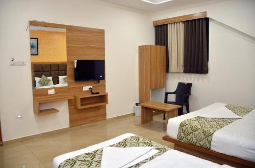 a hotel room with two beds and a television at Hotel Newyork Inn in Anand