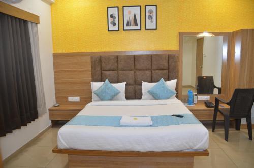 a bedroom with a large bed and a desk at Hotel Newyork Inn in Anand
