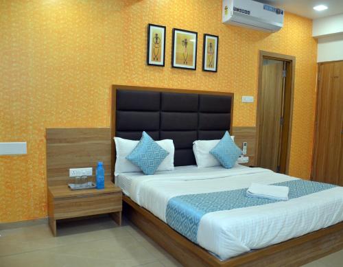 a bedroom with a large bed with blue pillows at Hotel Newyork Inn in Anand