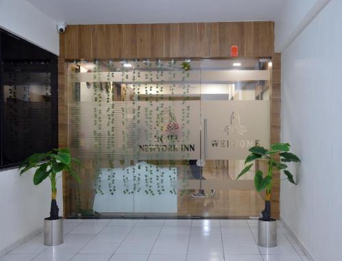 a store front with two plants in front of a window at Hotel Newyork Inn in Anand
