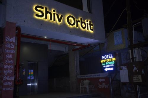 a sign for a shiv otop store at night at Hotel Newyork Inn in Anand