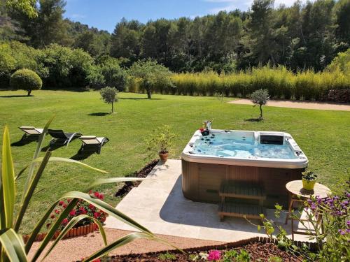 una bañera de hidromasaje en medio de un patio en Les Prairies de Fenestrelle Spa & Piscine au calme, en Aubagne