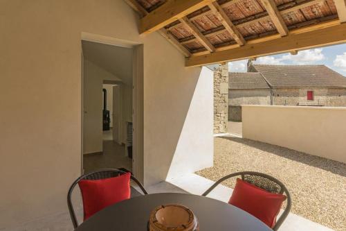 une table et des chaises sur le balcon d'une maison dans l'établissement Gîte de la Fontaine, à Baubigny