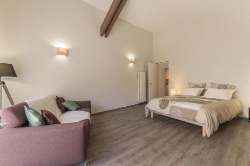 1 dormitorio con 1 cama y 1 sofá en Gîte de la Fontaine, en Baubigny