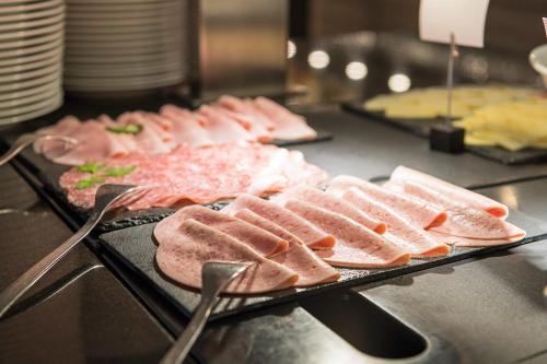 a buffet line with meat and bread on trays at WONNEMAR Resort-Hotel in Wismar