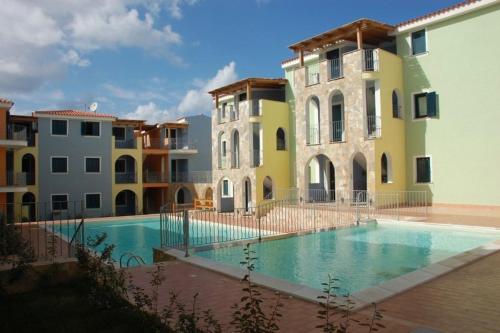 a swimming pool in front of two buildings at Sea Paradise Apartment in Valledoria
