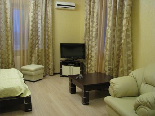 a living room with a couch and a tv at Hotel Grant in Kharkiv