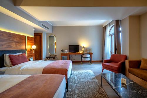 una habitación de hotel con dos camas y un sofá en Tiflis Palace, en Tiflis