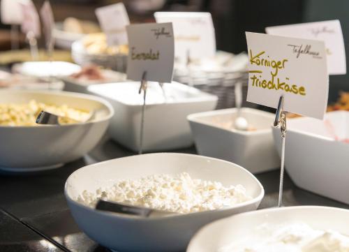 a table topped with bowls of rice and signs at WONNEMAR Resort-Hotel in Wismar