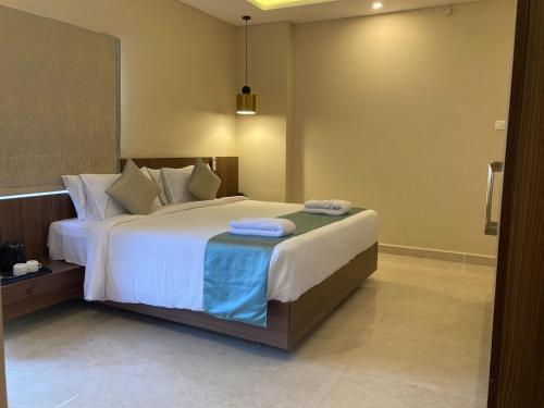 a bedroom with a large bed with towels on it at CORAL RESIDENCY in Rāmanāthapuram
