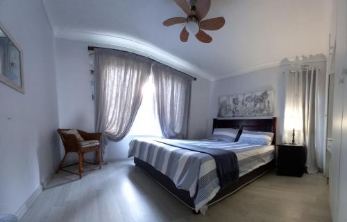 a bedroom with a bed and a ceiling fan at Laguna la Crete 99, Uvongo in Margate