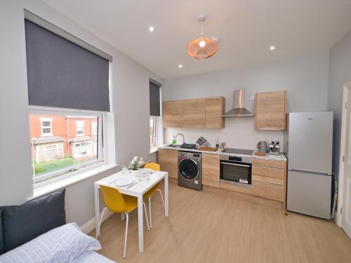 a small kitchen with a table and a refrigerator at Stunning property fully refurbished in Birmingham