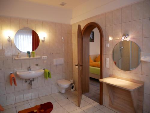 a bathroom with a sink and a toilet and a mirror at Wochner's Hotel-Sternen Am Schluchsee Hochschwarzwald in Schluchsee