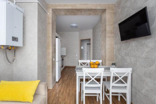 a dining room with a white table and chairs at 0102 квартира в Софія Резиденс, 5 поверх in Vyshneve