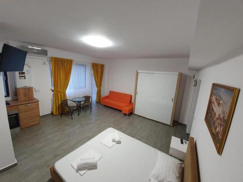 a living room with an orange couch and a table at Brizza Apartments 5 Mamaia Nord in Mamaia Nord